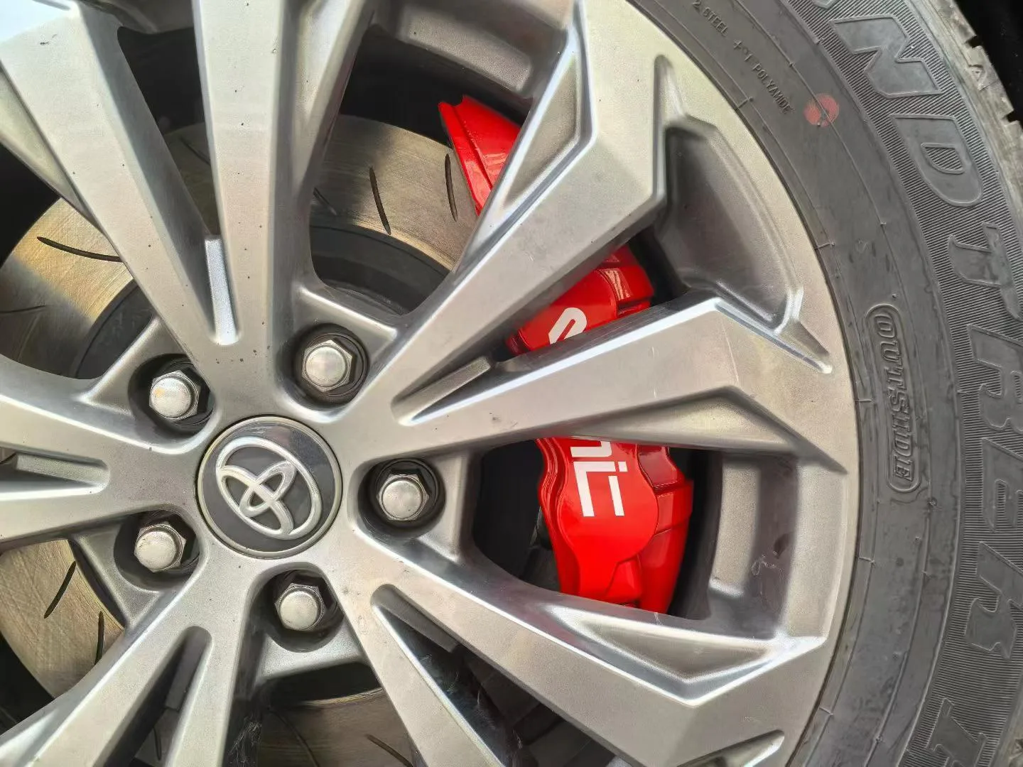 Toyota RAV4 factory wheel with red VINIC big brake caliper behind spokes