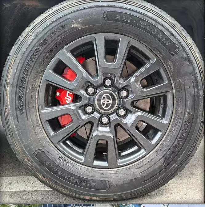 VINIC red caliper behind the factory wheel on a Toyota Land Cruiser