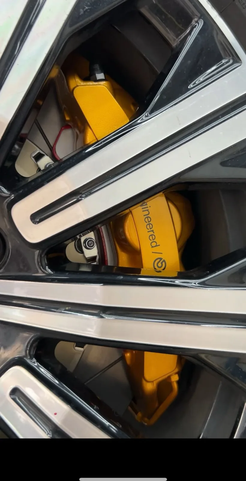 Close-up of gold 6-piston caliper behind Volvo XC90 wheel